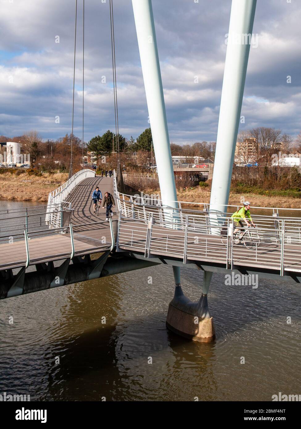 Lancaster, Inghilterra, Regno Unito - 2 aprile 2013: I ciclisti attraversano il fiume Lune sul Millennium Bridge Foot and Cycleway di Lancaster, parte del National Cycle Netwo Foto Stock