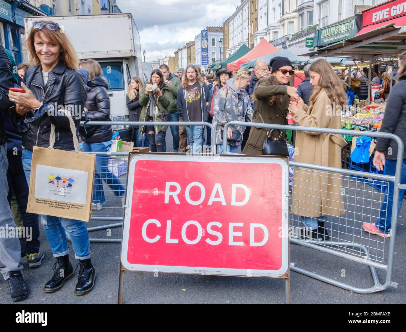 Cartello stradale chiuso con folla di pedoni al mercato di Portobello. Londoners & turisti shopping & godere una giornata fuori. Portobello Road, Notting Hill Foto Stock