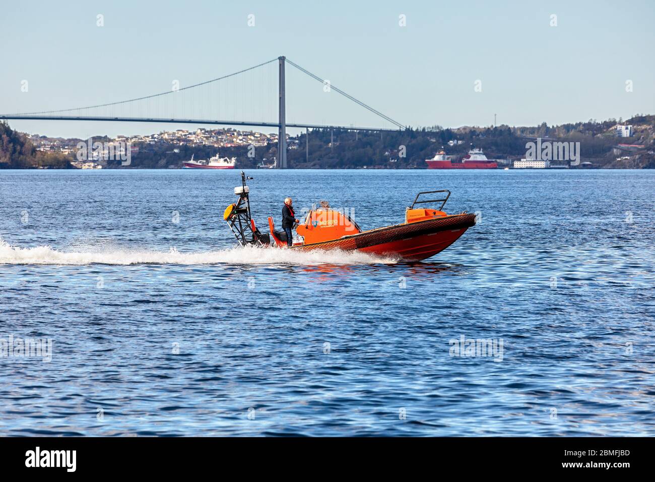 STCW Hurtiggående MOB-båt, a Byfjorden fuori dal porto di Bergen, Norvegia. Ponte sospeso Askoeybroen sullo sfondo Foto Stock