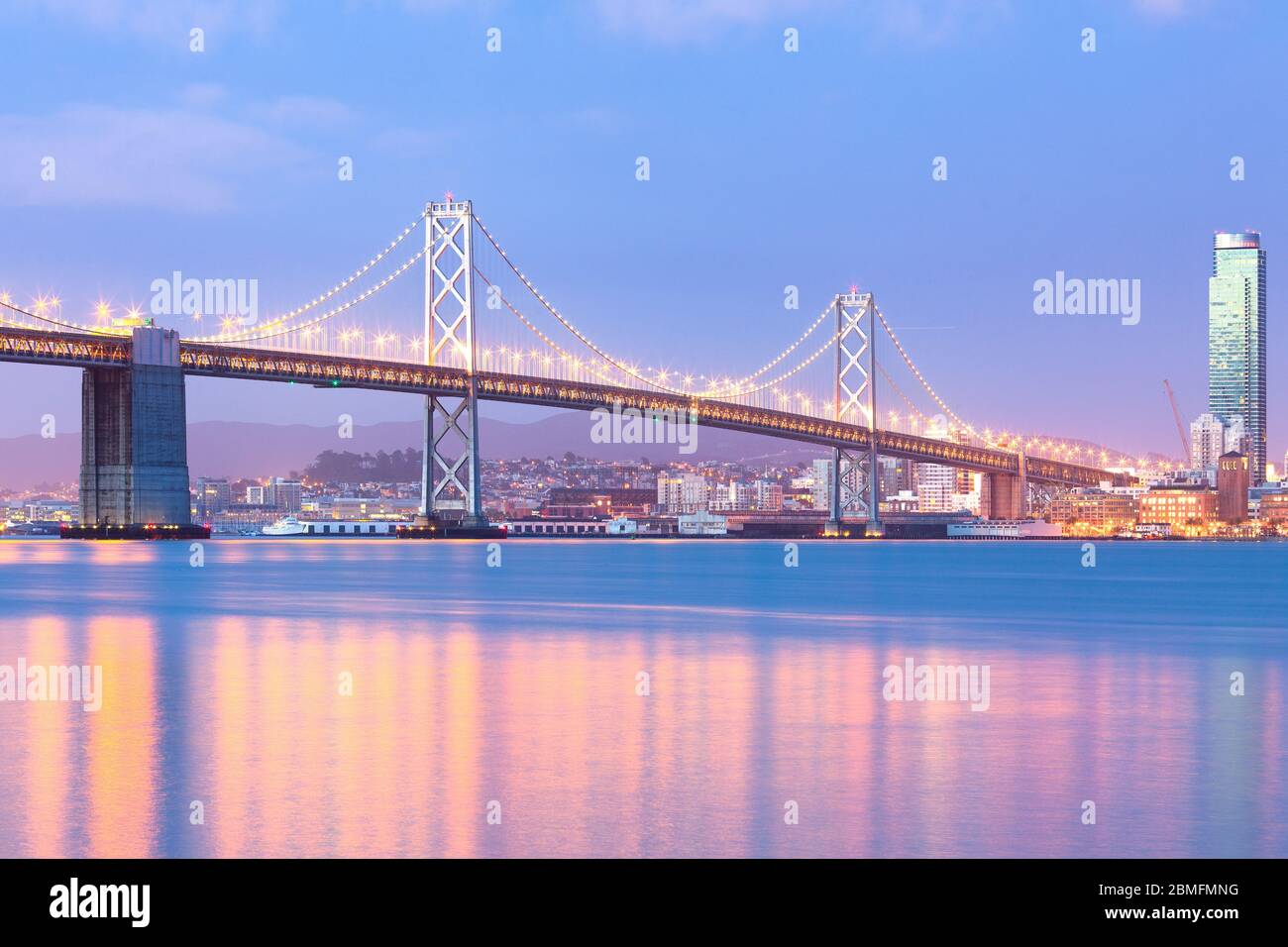 Una vista illuminata san francisco-oakland Bay Bridge all'alba, San Francisco, California, Stati Uniti Foto Stock