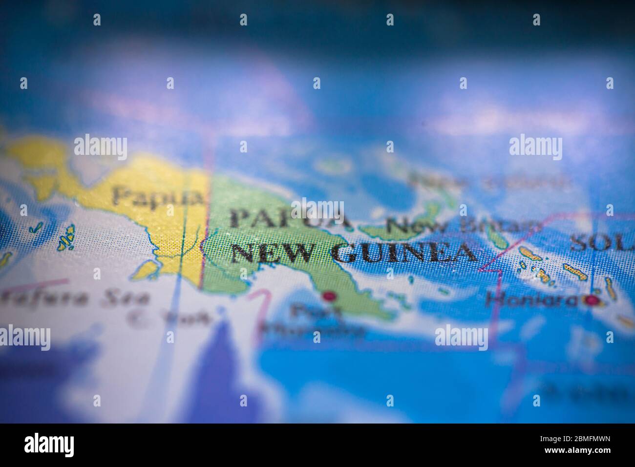 Profondità di campo poco profonda fuoco sulla mappa geografica posizione del paese Papua Nuova Guinea in Asia Oceania continente su atlas Foto Stock