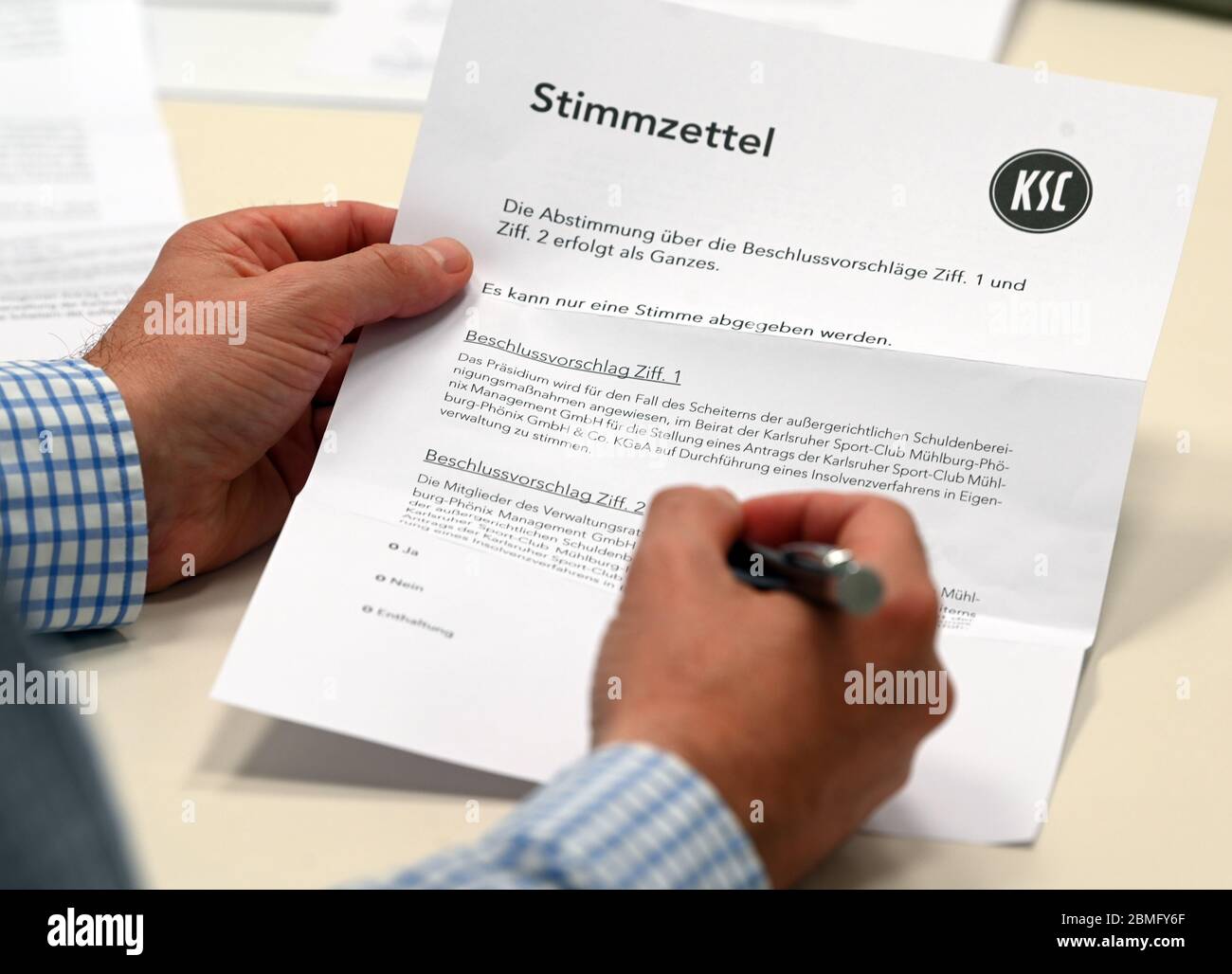 Karlsruhe, Germania. 9 maggio 2020. Un membro del club della seconda divisione Karlsruher SC compila un documento di voto per una votazione postale. Il club di calcio di seconda divisione fortemente indebitato vuole che i suoi membri votino online in occasione di una riunione straordinaria del 15 maggio 2020 sulla prevista insolvenza in materia di auto-amministrazione. Chiunque non sia in grado di partecipare alla riunione avrà la possibilità di votare per posta. Credit: Uli Deck/dpa/Alamy Live News Foto Stock