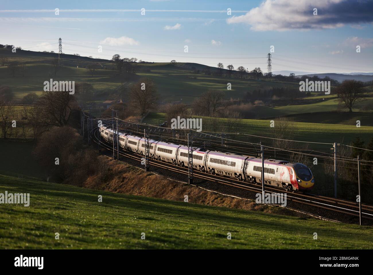 Virgin Trains Alstom Pendolino treno 390017 che attraversa la campagna sulla costa occidentale della Cumbria Foto Stock