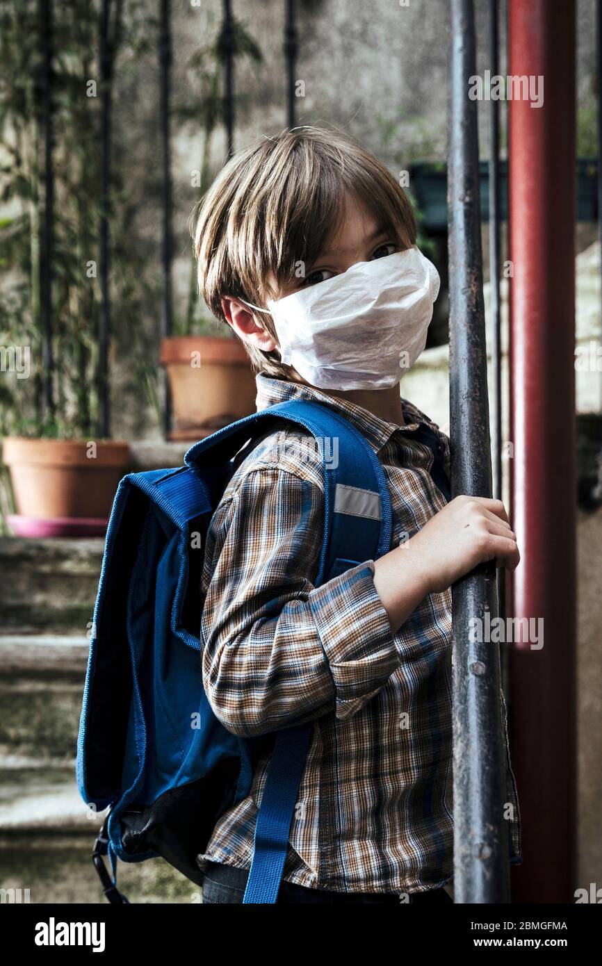 Focolaio di coronavirus, Covid-19: Illustrazione sulla riapertura delle scuole. Scolaretto con zaino e maschera protettiva, il 30 aprile 2020 Foto Stock