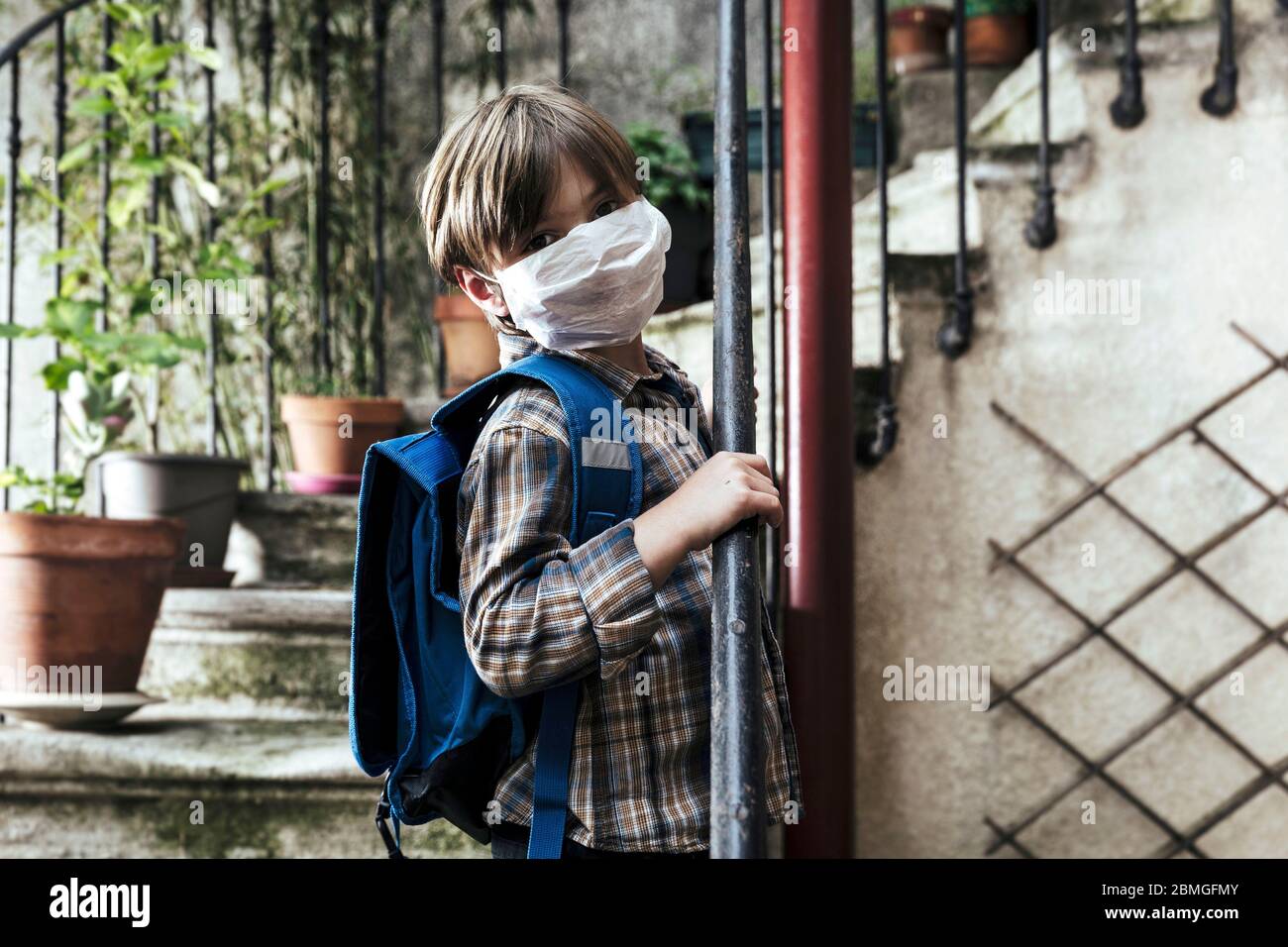 Focolaio di coronavirus, Covid-19: Illustrazione sulla riapertura delle scuole. Scolaretto con zaino e maschera protettiva, il 30 aprile 2020 Foto Stock