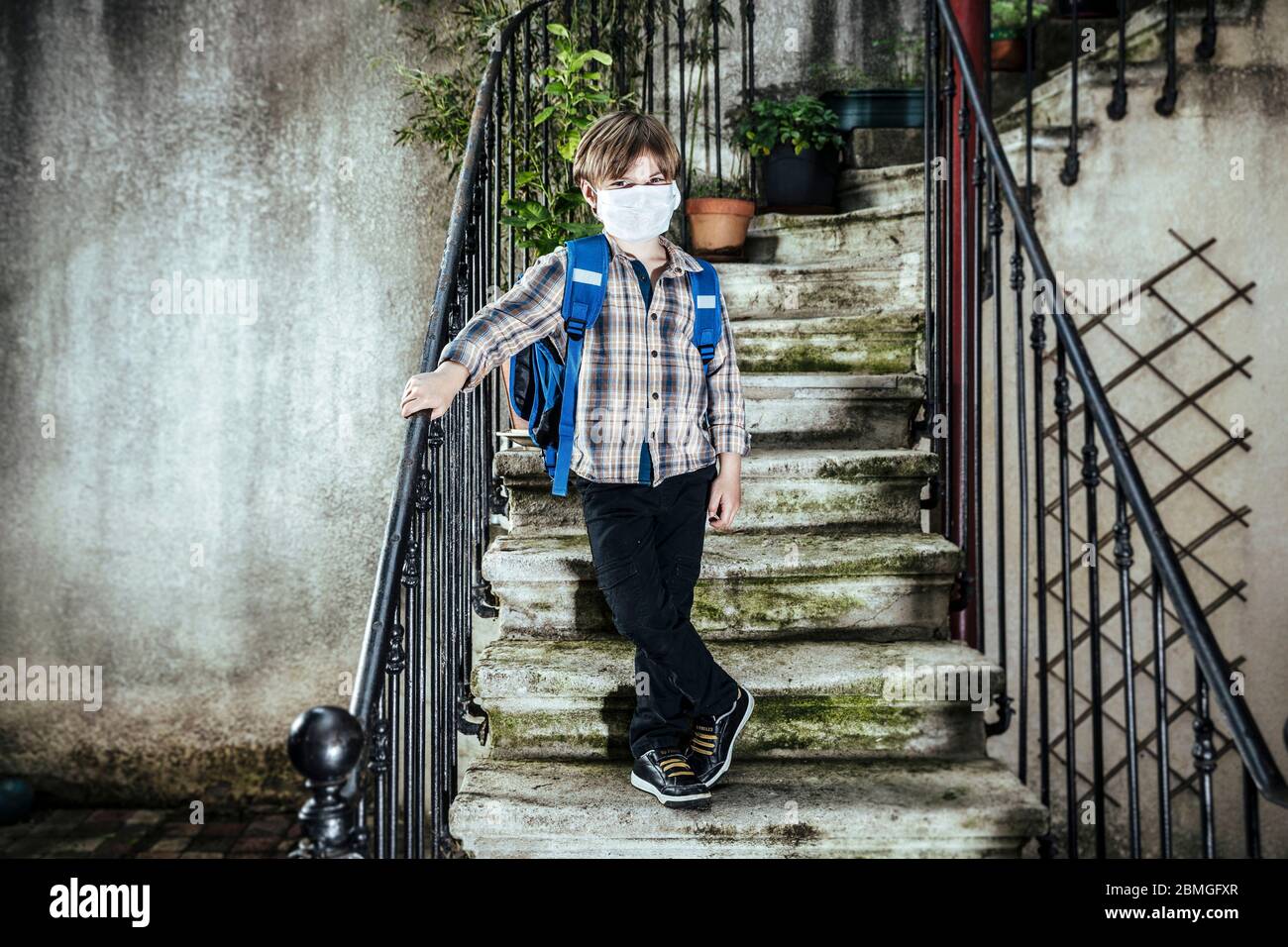 Focolaio di coronavirus, Covid-19: Illustrazione sulla riapertura delle scuole. Scolaretto con zaino e maschera protettiva, il 30 aprile 2020 Foto Stock