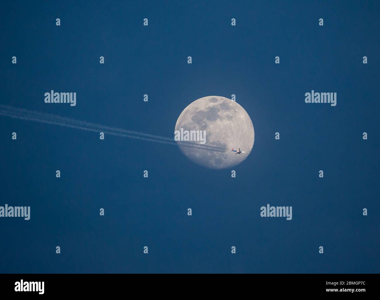 Un aereo di linea Allegiant Airlines passa davanti a una luna piena ad alta quota. Foto Stock