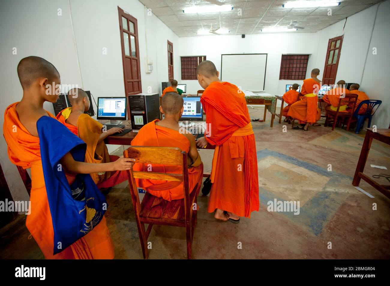 GIOVANI BUDDISTI MONACI CHE USANO COMPUTER A LUANG PRABANG, LAOS Foto Stock