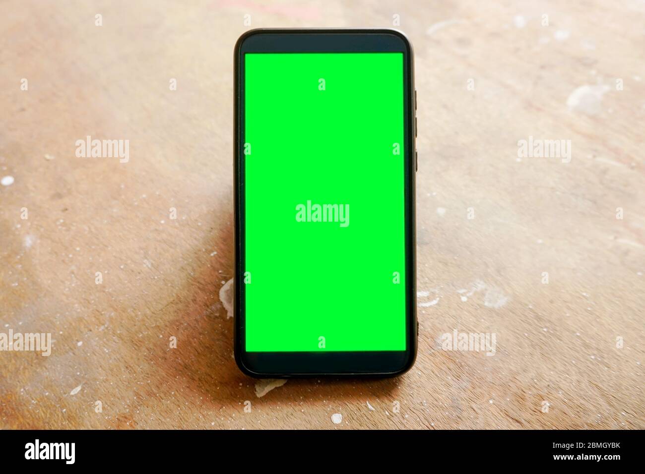 tenere la mano con lo smartphone con schermo verde Foto Stock