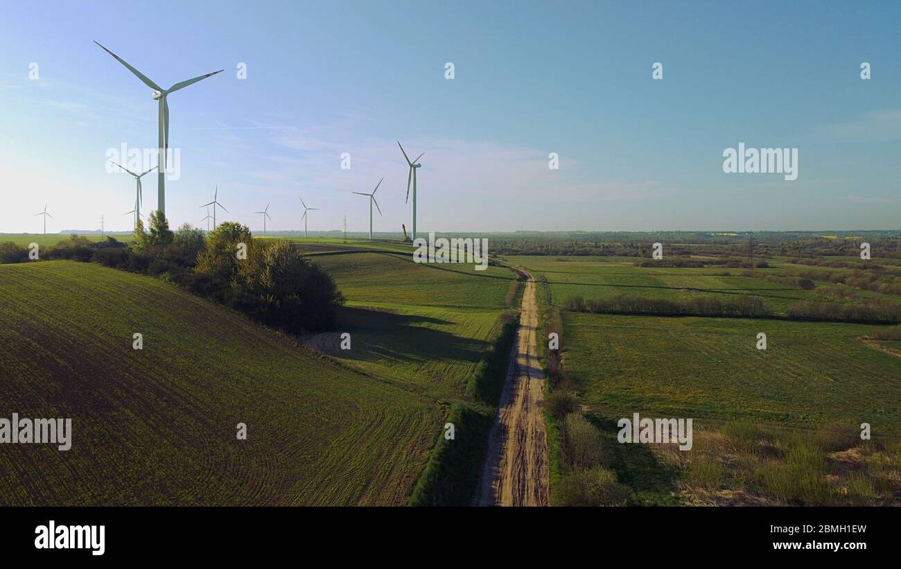 Torri eoliche circondate da campi agricoli nel lato della campagna polacca. Pomerania, Polonia. Foto Stock