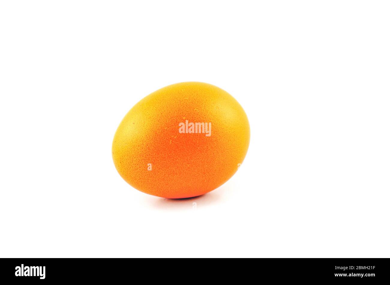 Uovo di pasqua di colore giallo o arancione isolato su sfondo bianco, colorato da coniglio di pasqua Foto Stock