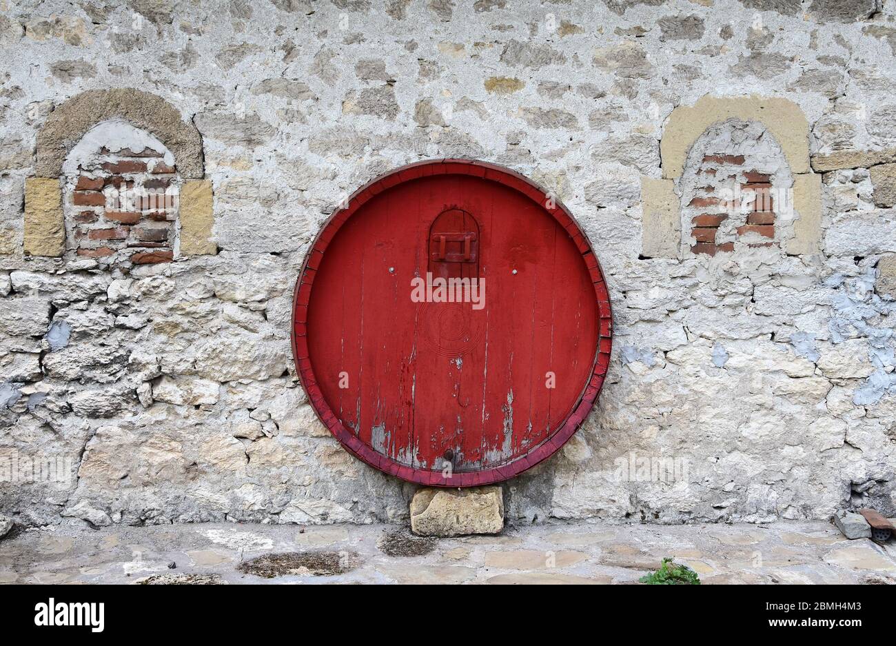 Botte rossa su muro di pietra sulla casa del vino Foto stock - Alamy