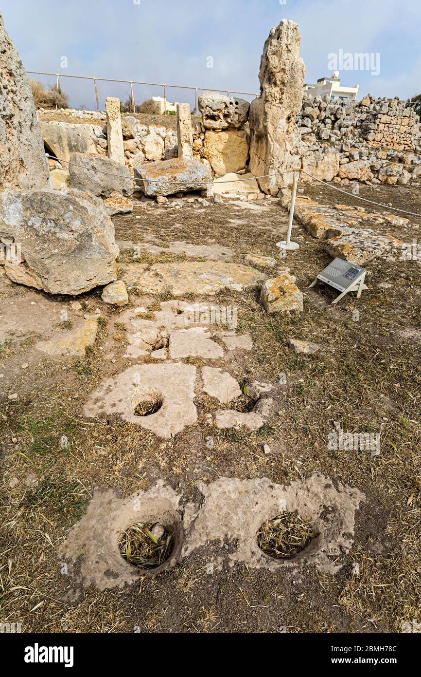 Fori di libazione nel passaggio d'ingresso, rovine del tempio di Skorba, Triq Sant'Anna, Mgarr, Malta Foto Stock