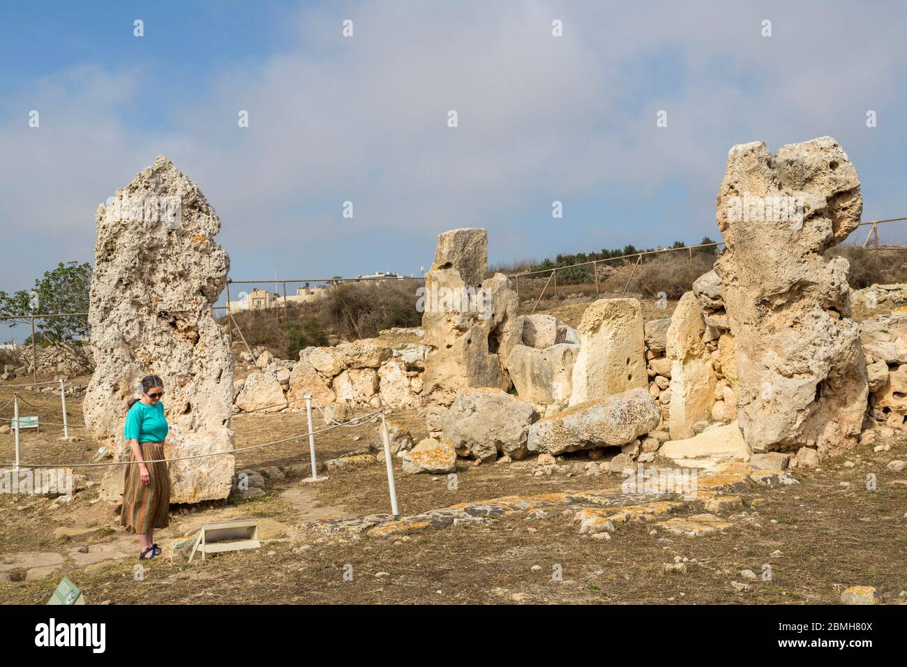 Donna che legge il cartello informativo presso le rovine del tempio di Skorba, Triq Sant' Anna, Mgarr, Malta Foto Stock