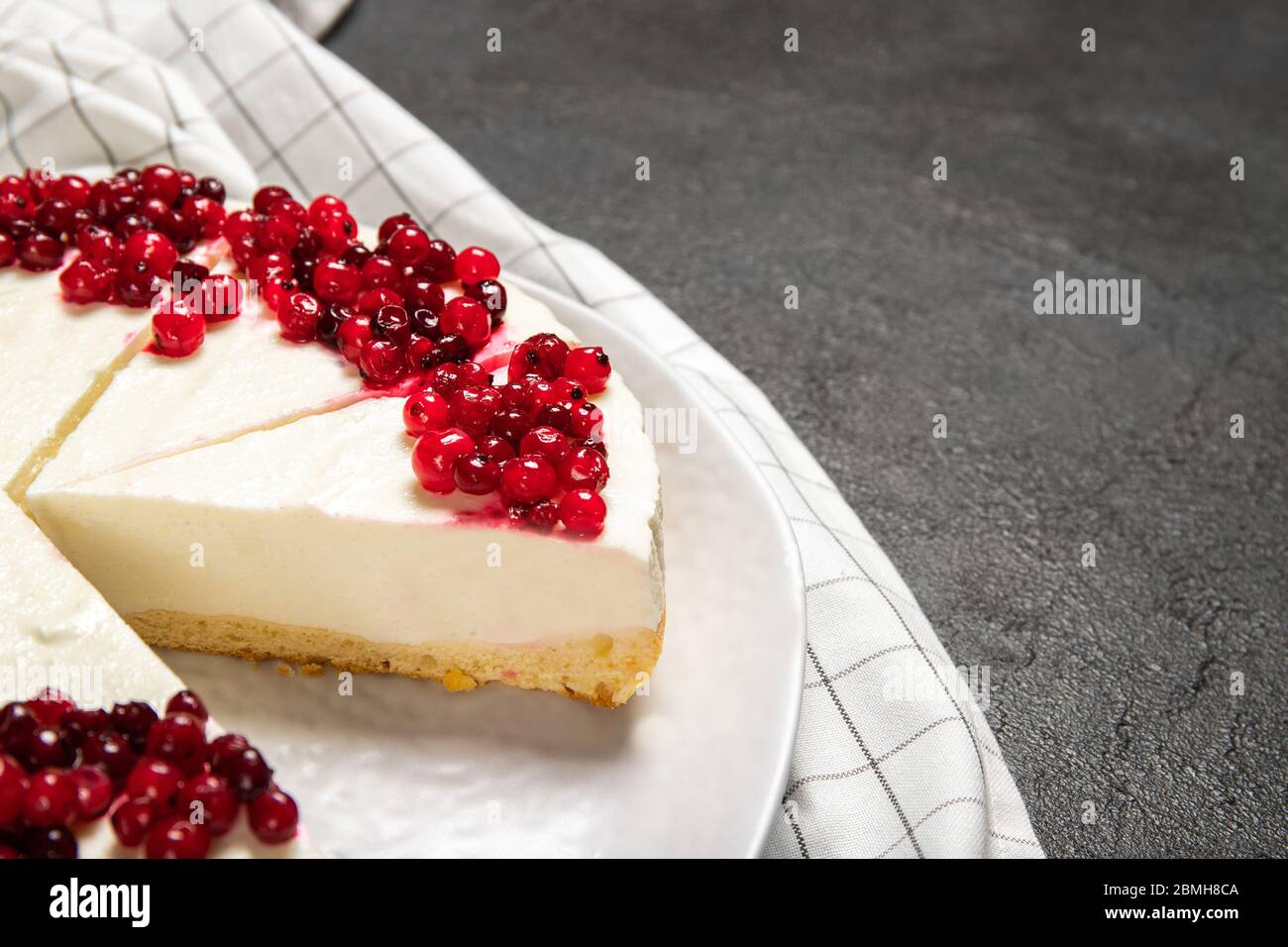 Piatto con delizioso cheesecake e frutti di bosco freschi sul tavolo Foto Stock