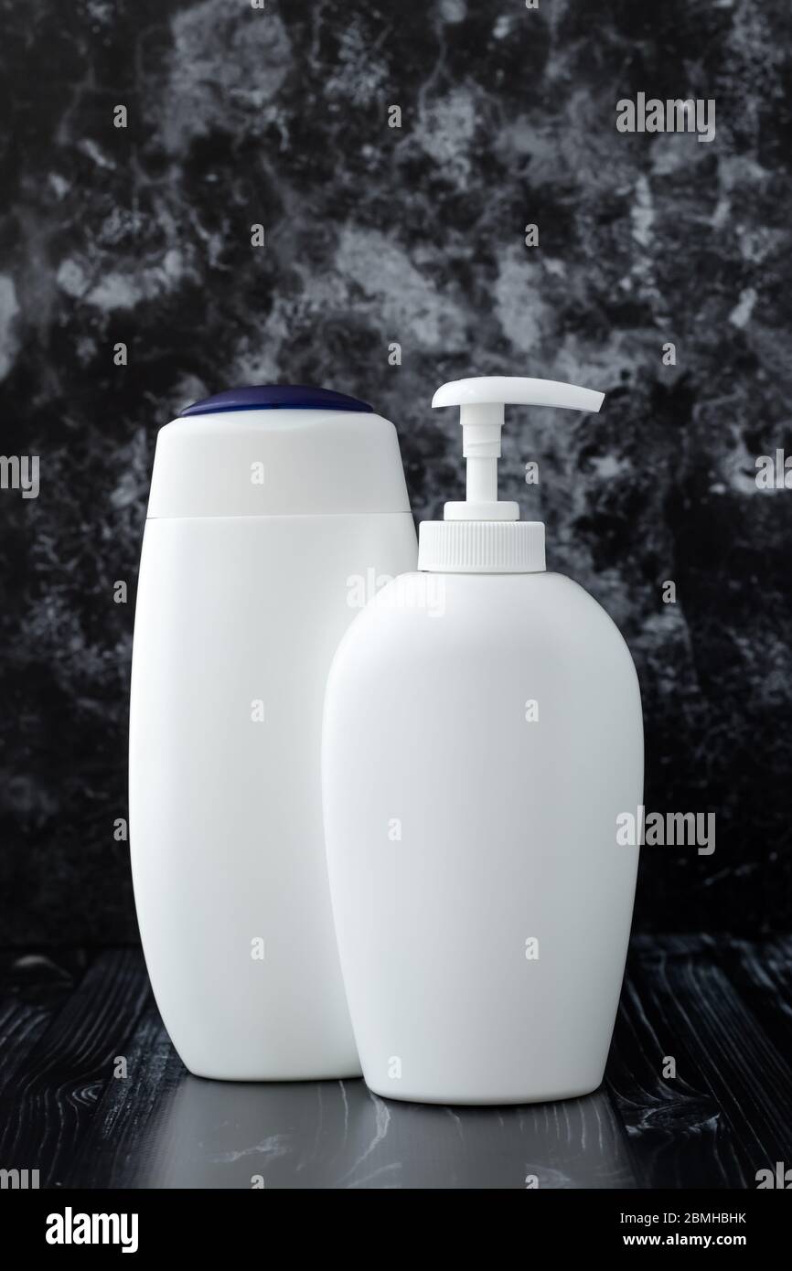 Set di bottiglie cosmetiche. Sapone liquido e gel doccia, concetto di igiene. Bagno con articoli da toeletta su sfondo in marmo nero Foto Stock