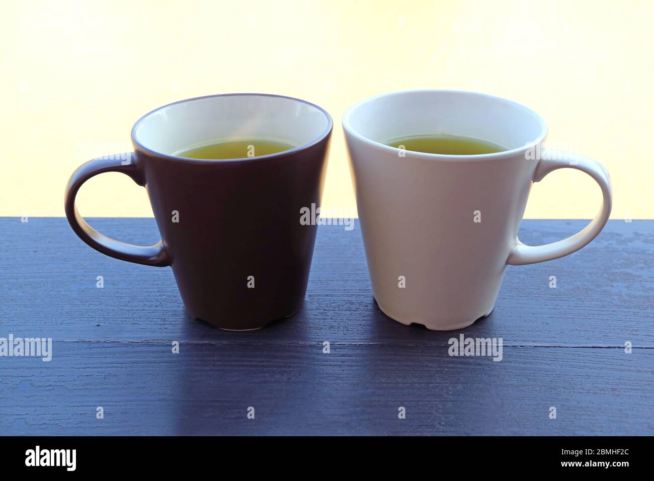 Due tazze di tè verde su un tavolo in legno sul lungomare con una concentrazione selettiva Foto Stock