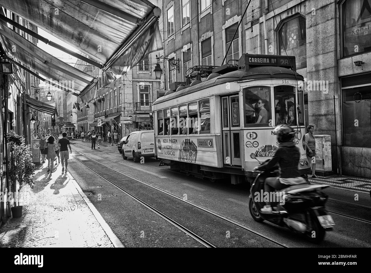Un tram si sposta lungo una strada nella zona della città vecchia di Lisbona, Portogallo. Foto Stock