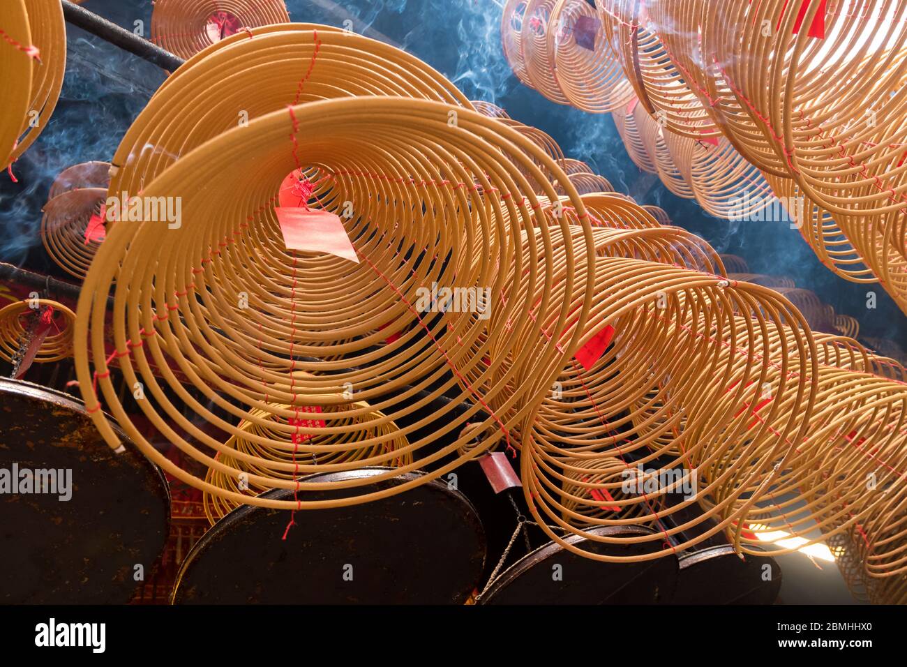 Bastone di incenso beige avvolto appeso in un tempio buddista Foto Stock