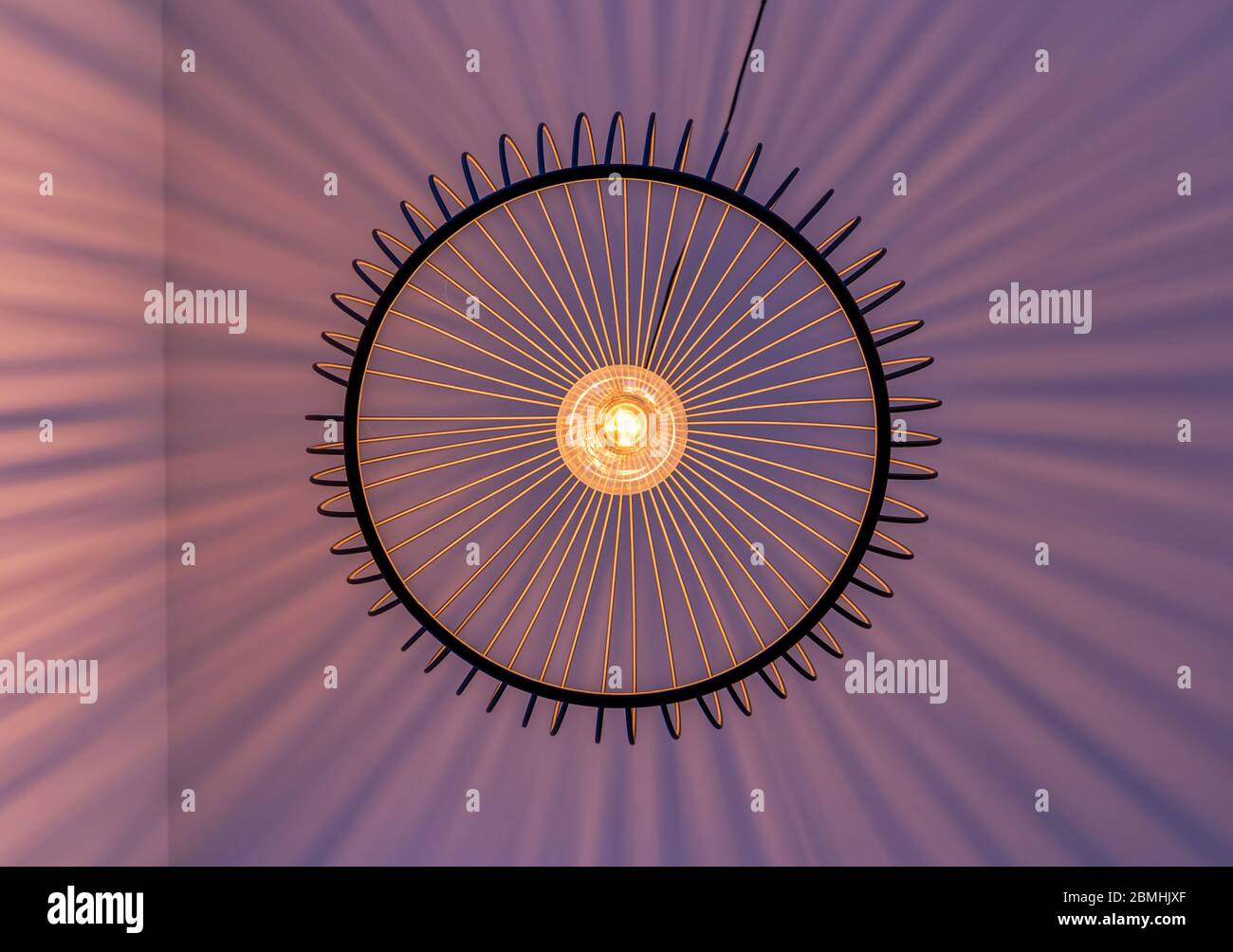 Raggi luminosi geometrici disposti di una lampada fotografati in modo eccellente dal basso in verticale. Foto Stock
