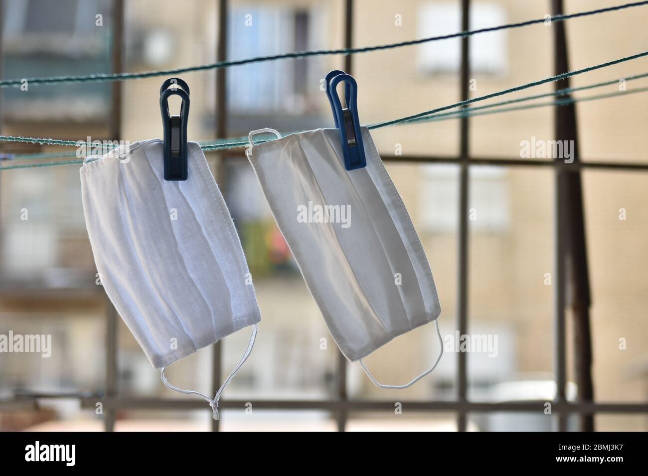 Maschere facciali di protezione fatte a mano appese per asciugarsi dopo il lavaggio. Foto Stock
