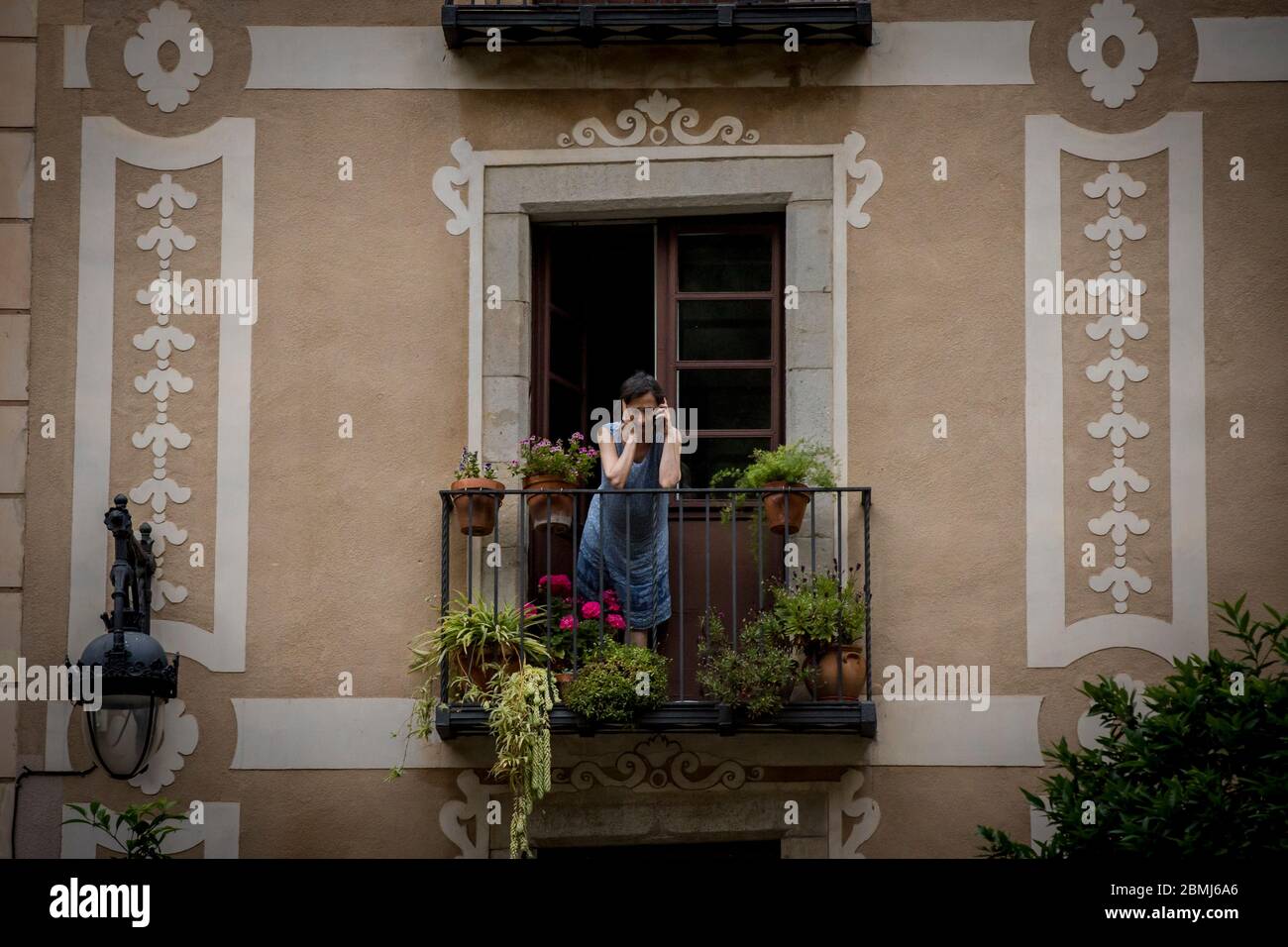 Barcellona, Spagna. 9 maggio 2020 - Donna è sul suo balcone nel centro di Barcellona. Il primo ministro spagnolo chiede cautela prima della prossima fase di deescalation, la Spagna si prepara ad un ulteriore allentamento delle misure di confinamento. Credit:Jordi Boixareu/Alamy Live News Foto Stock