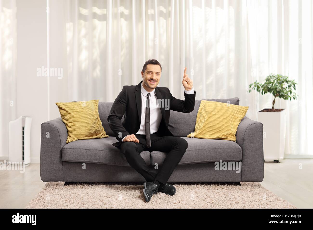 Uomo d'affari seduto su un divano e rivolto verso l'alto Foto Stock