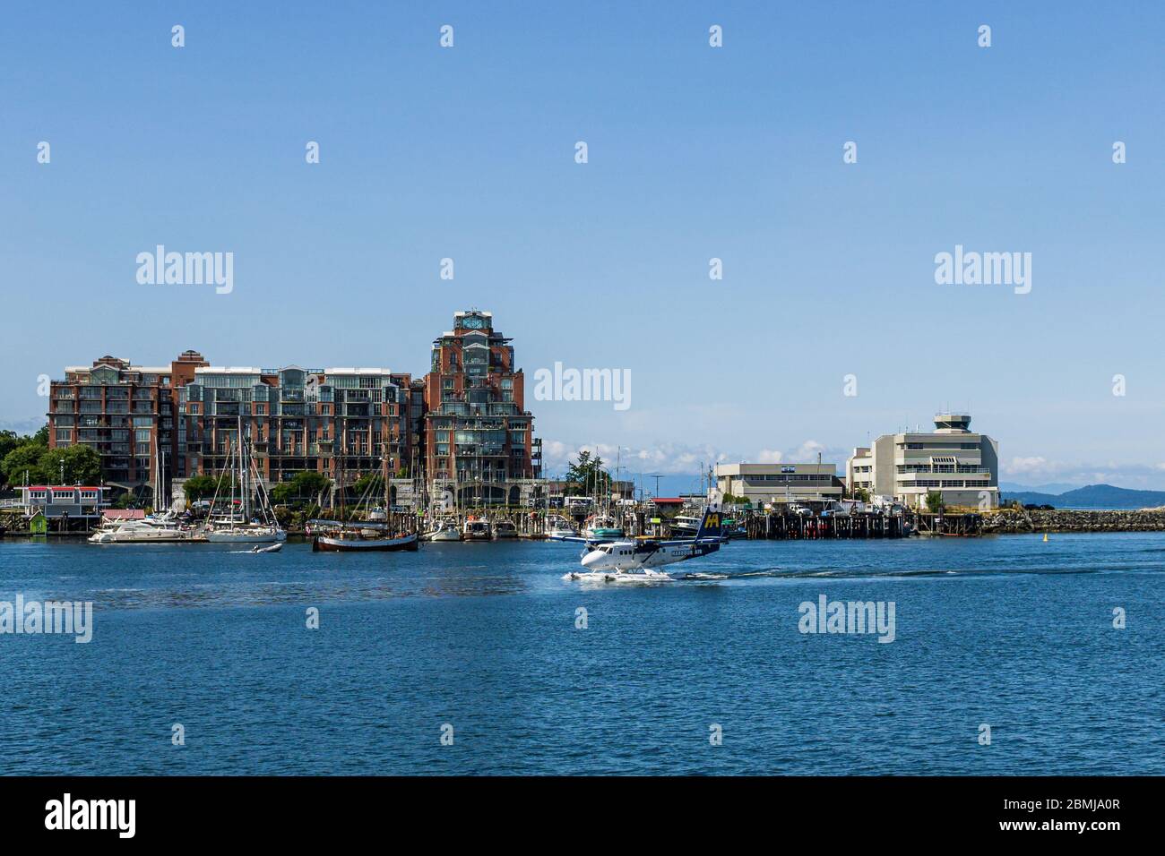 VICTORIA, CANADA - 14 LUGLIO 2019: Porto trafficato nella zona del centro con yacht e aeroplano. Foto Stock