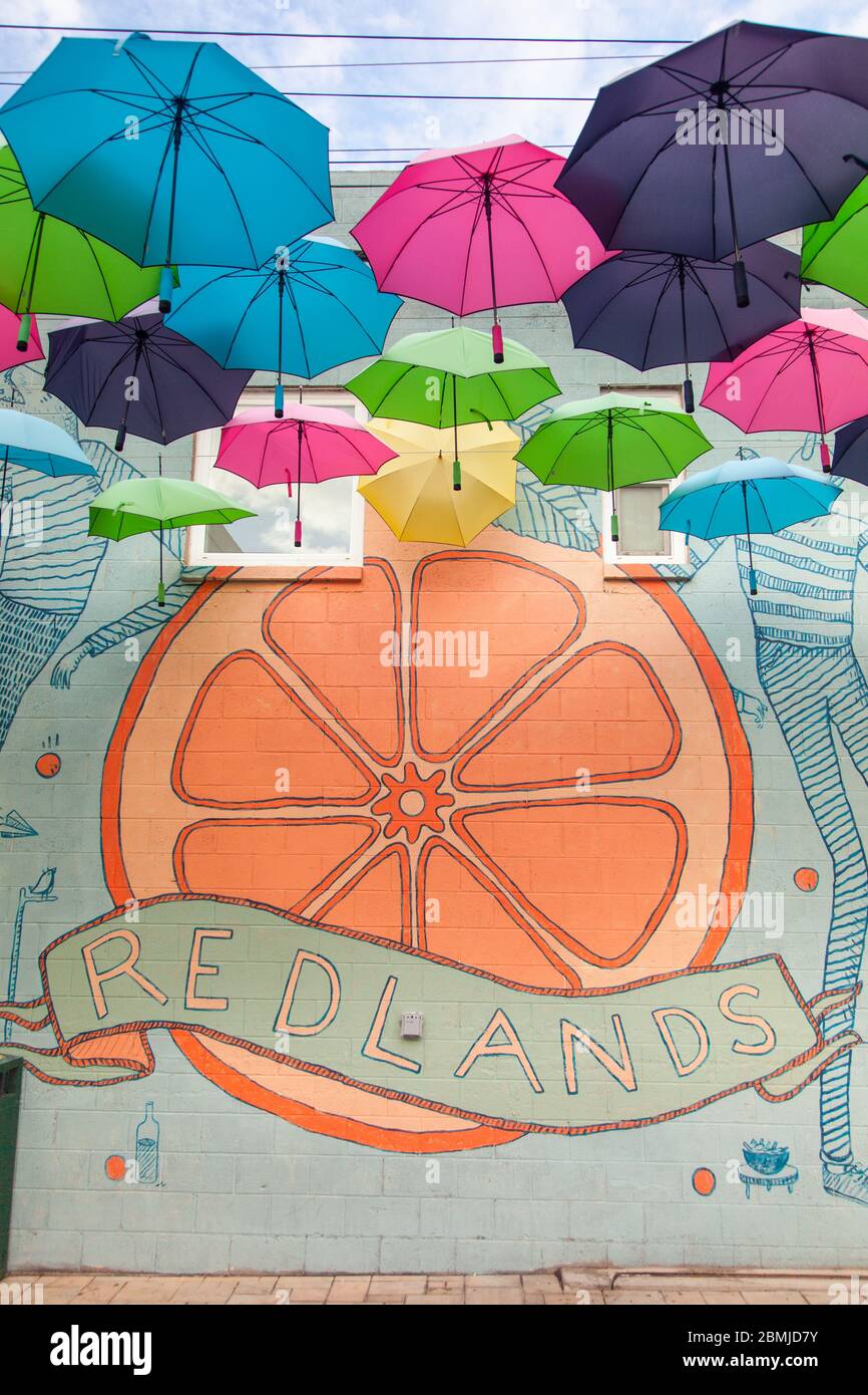 Muro murale su Orange Street Alley a Redlands, CA per gli ombrelloni sospesi sotto Foto Stock