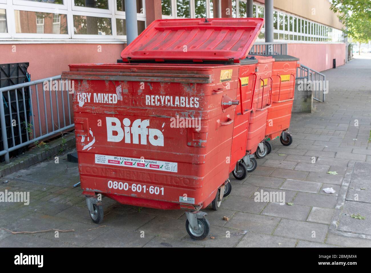 Bristol-Maggio 2020-Inghilterra-un primo piano di quattro bidoni di riciclaggio rosso fuori di un blocco di appartamenti Foto Stock