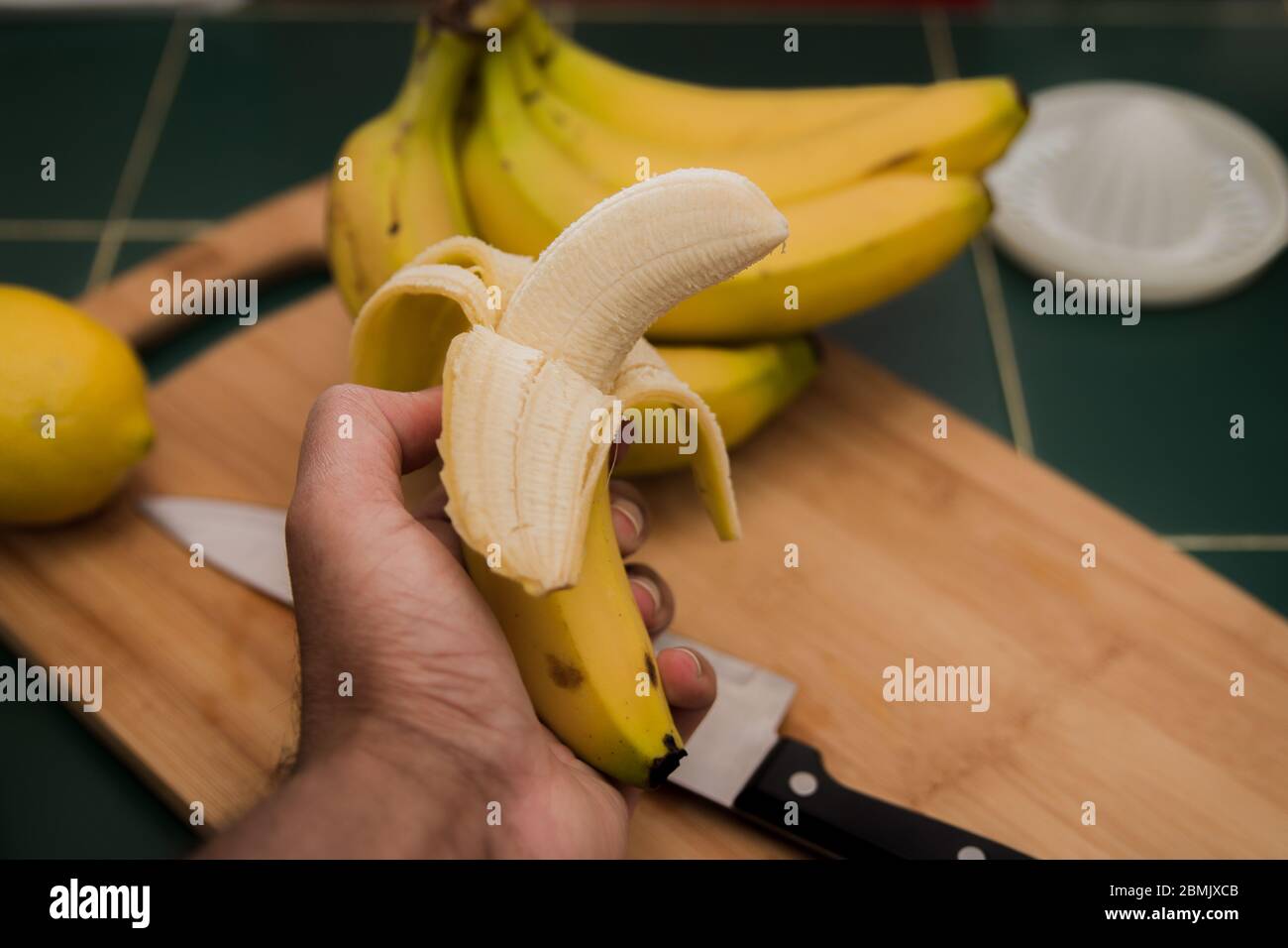 Banana pelata in mano di un uomo Foto Stock