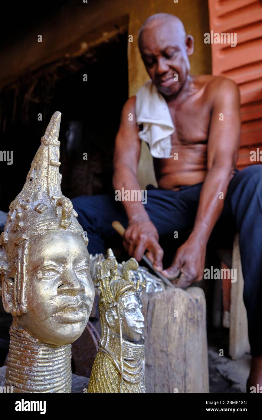 Artigiano rifinendo lucidando gli ultimi dettagli di una statuetta di bronzo realizzata con la tecnica della fusione a cera persa, utilizzata nel regno di BE Foto Stock