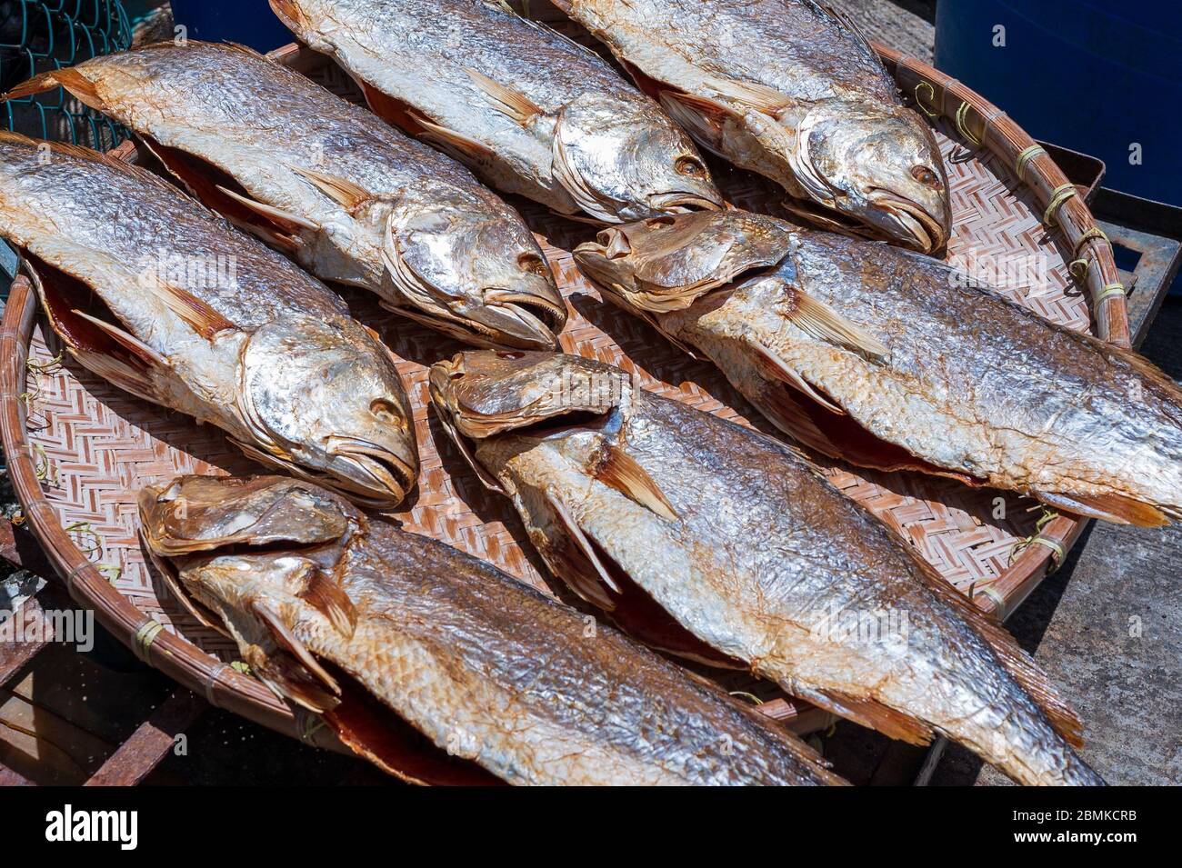 Pesce piccolo essicato in stile cinese tradizionale su un cesto di canna Foto Stock