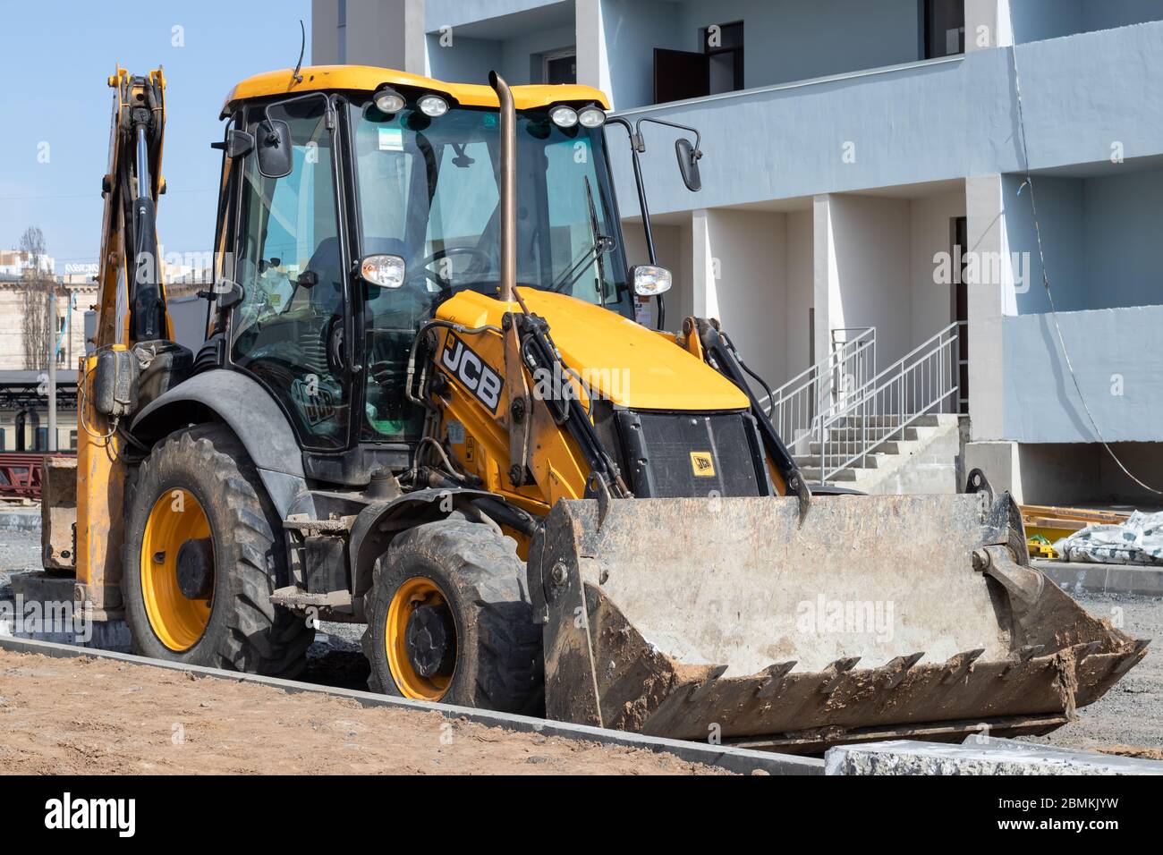 Kharkiv, Ucraina, 29 marzo 2020: Escavatore JCB parcheggiato all'esterno. Il trattore giallo sporco nel cantiere. Veicolo europeo, apripista con bu Foto Stock