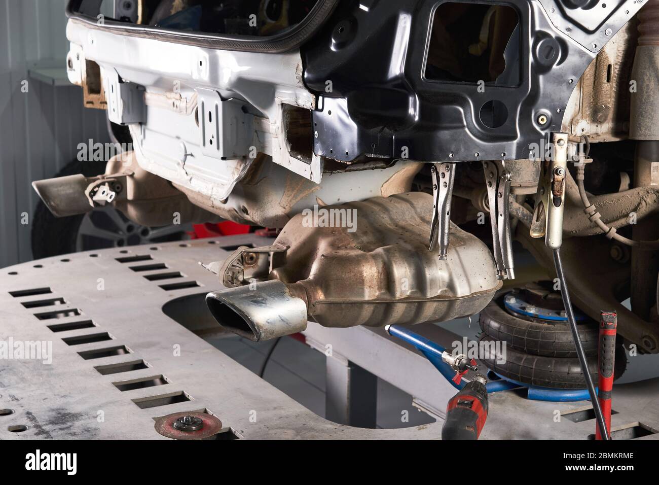 Auto in piedi su una piattaforma di sollevamento per la riparazione in officina di assistenza auto Foto Stock