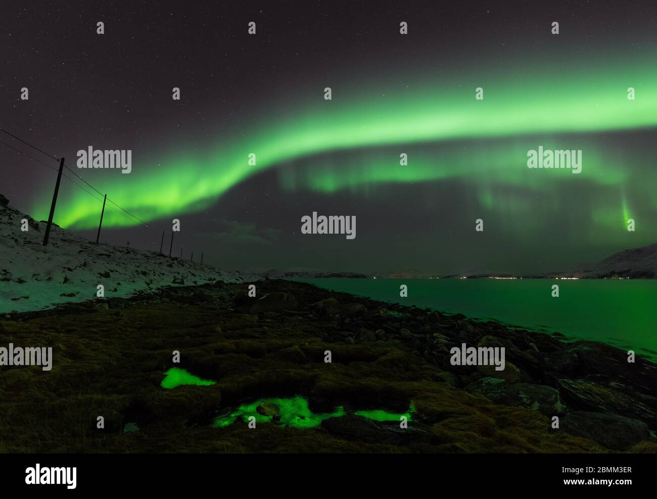 Luci verdi che illuminano la terra e il cielo Foto Stock