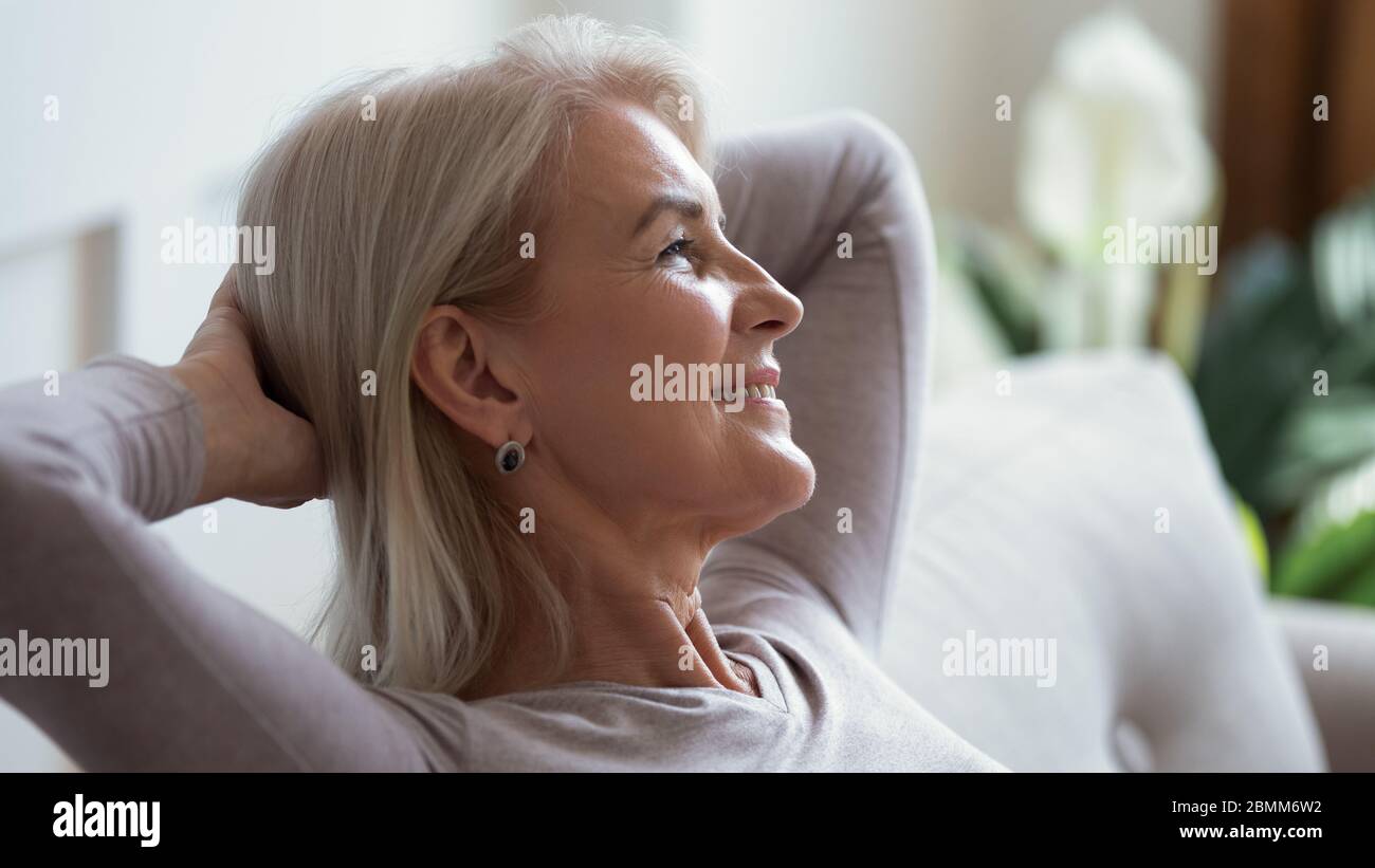 Calma donna matura rilassarsi sul divano sognare giorno Foto Stock