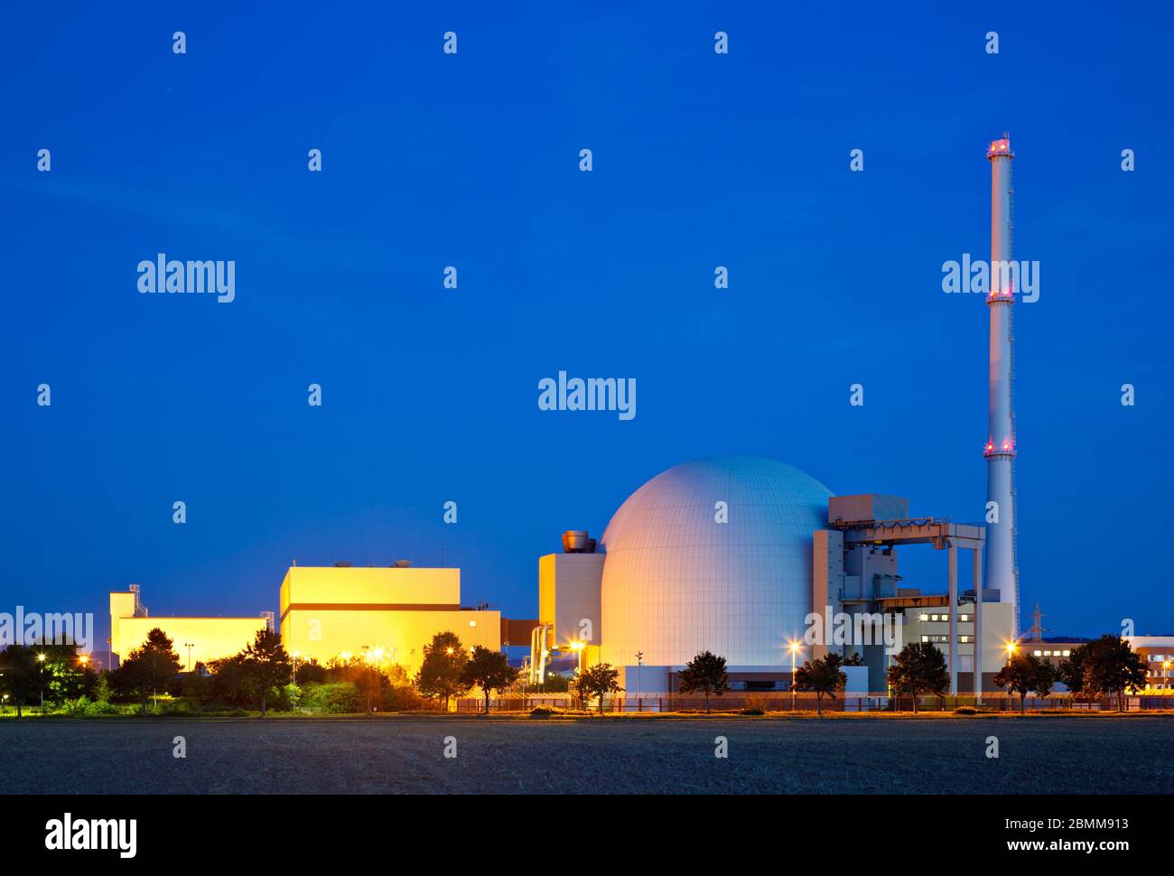 Costruzione di un reattore di una grande centrale nucleare con cielo blu notte. Foto Stock