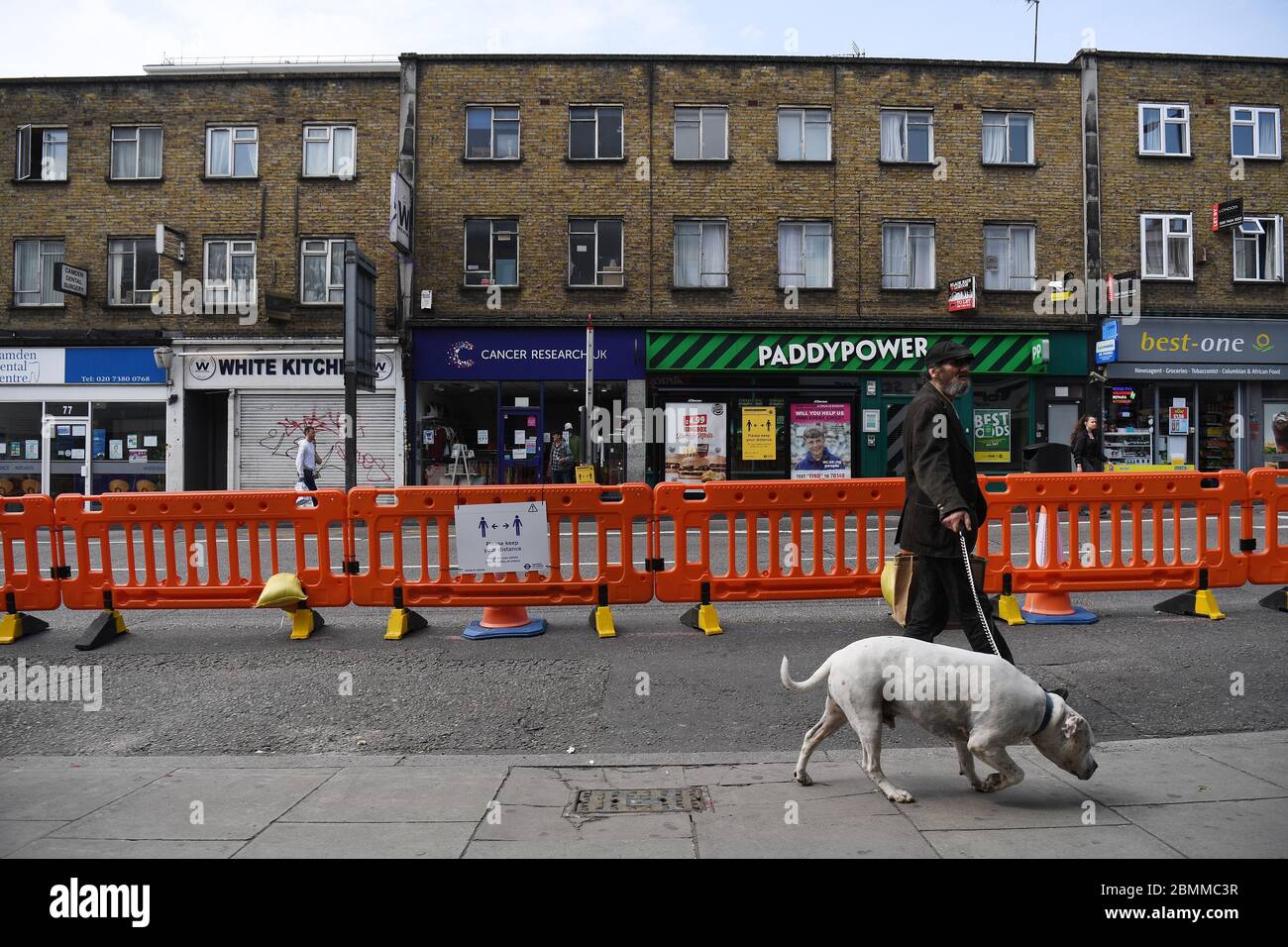 La gente si serve di una nuova pavimentazione ampliata per aiutare le distanze sociali su Camden High Street a Londra, mentre il Regno Unito continua a bloccarsi per contribuire a frenare la diffusione del coronavirus. Foto Stock
