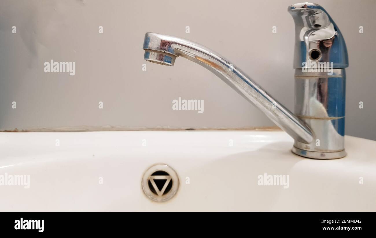 Rubinetto vecchio e sporco e lavabo in ceramica bianca, concetto di  pulizia, riparazione o sostituzione di un bagno, wc Foto stock - Alamy