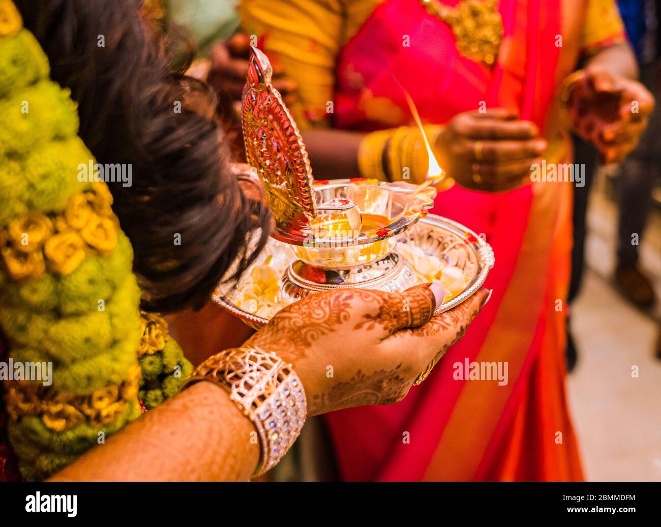 Una sposa che tiene una lampada d'argento come rituale durante un matrimonio indù del Sud-indiano Foto Stock