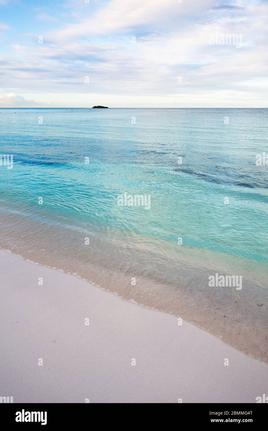 Eccezionalmente calmo mare dei caraibi a Jabberwock Beach in Antigua, sembra quasi computer grafica. La piccola isola è Prickly Pear Island. Foto Stock