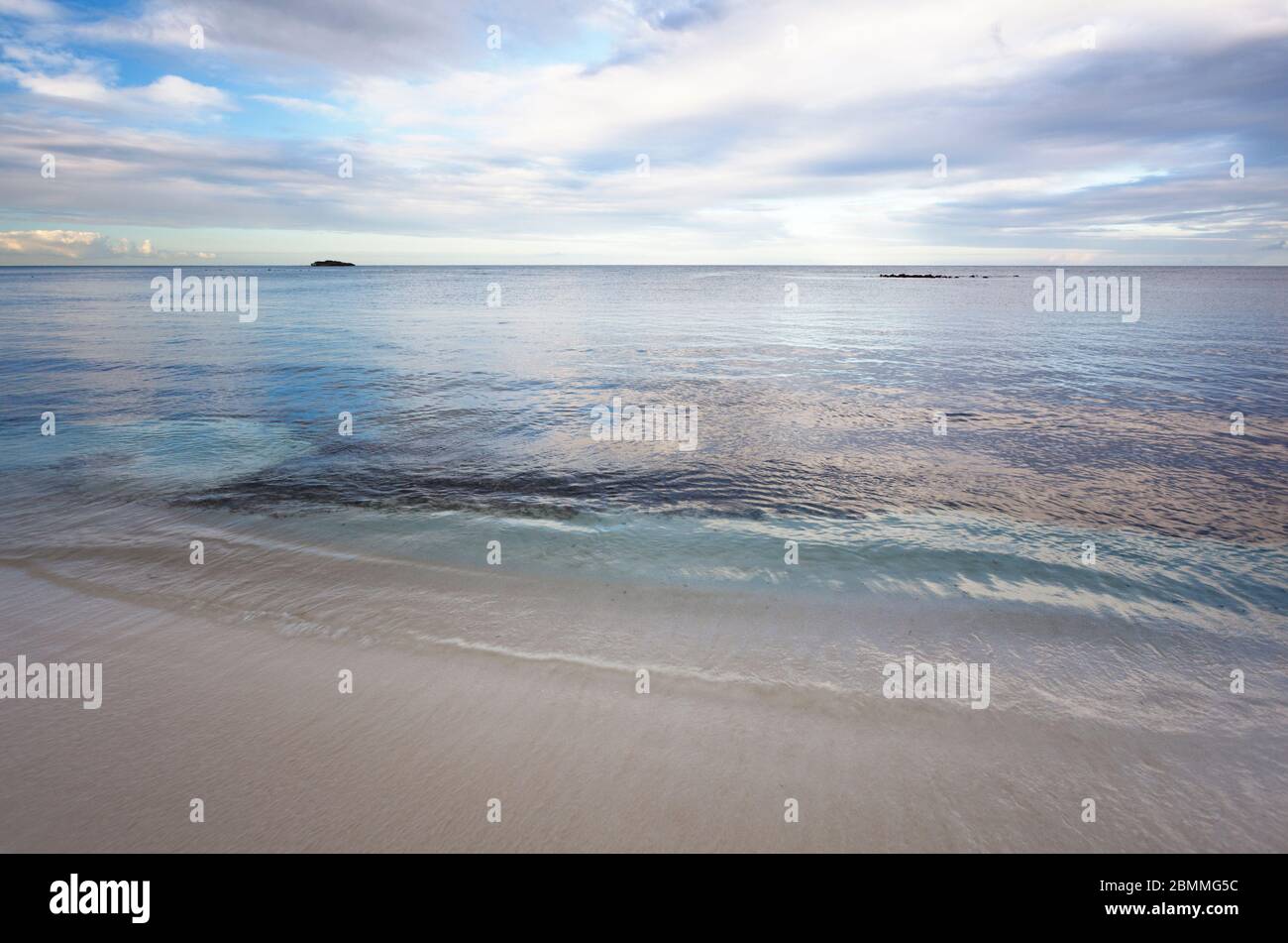 Eccezionale mare calmo a Jabberwock Beach ad Antigua, sembra quasi computer grafica. La piccola isola è Prickly Pear Island. Foto Stock