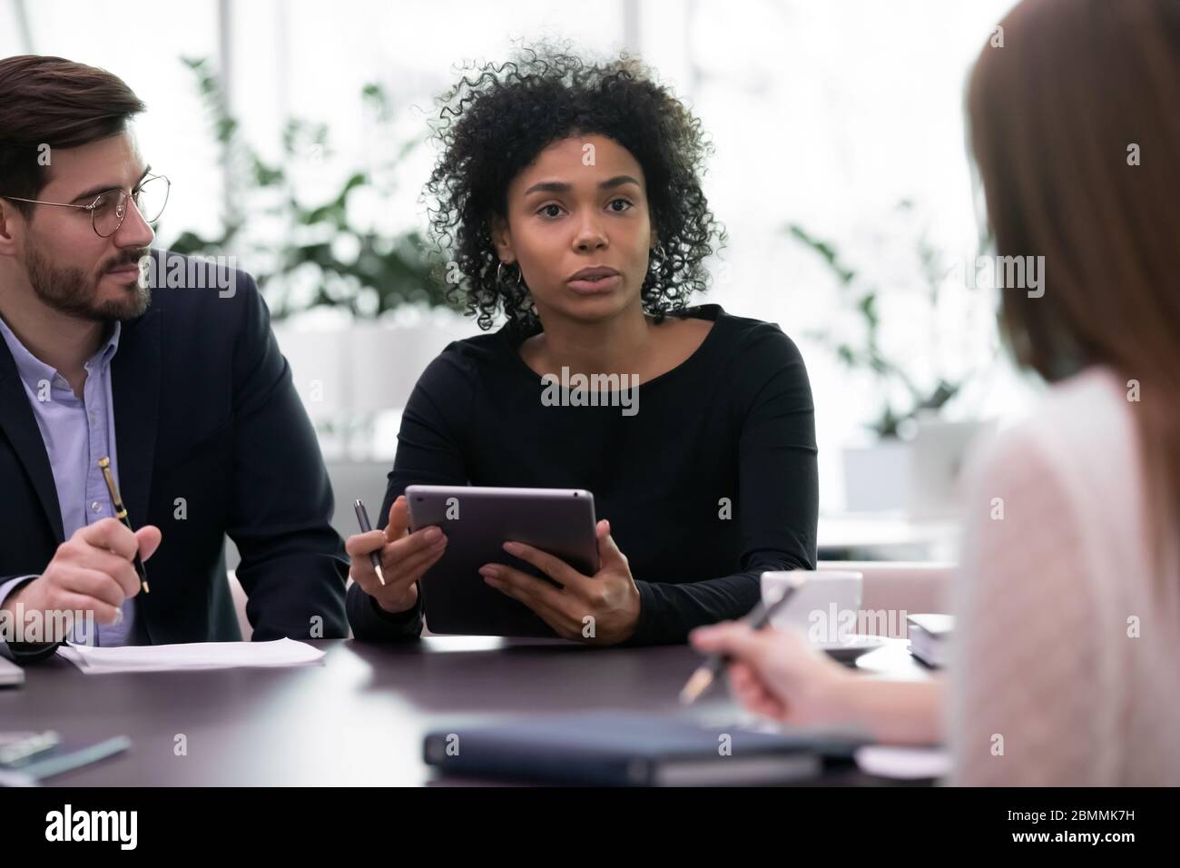 I partner multietnici si sono riuniti in sala di consiglio per negoziare la soluzione delle questioni attuali Foto Stock