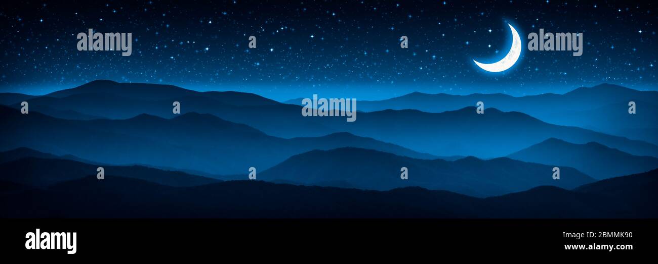 Luna Crescent e cielo stellato incandescente sulla catena montuosa di Foggy Foto Stock