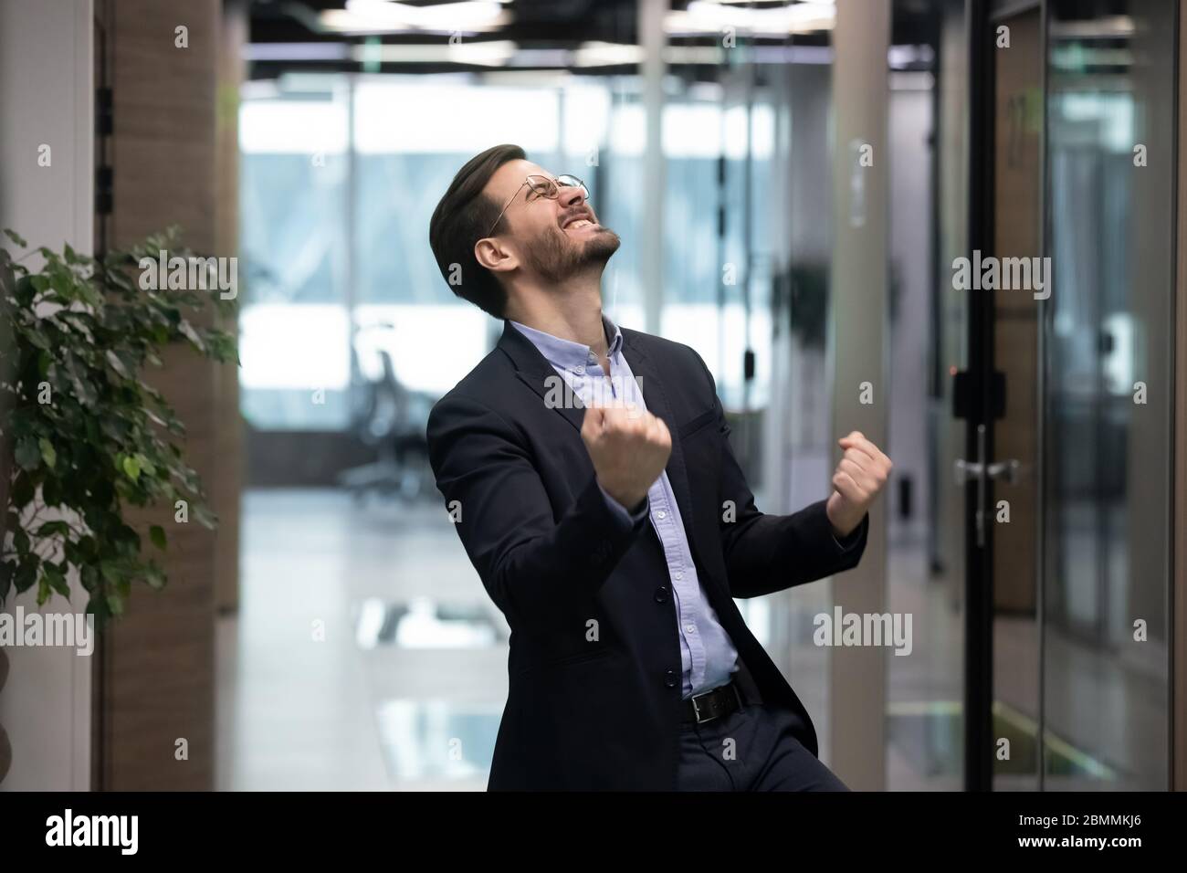 Il businessman riuscito si sente overjoyed celebrare l'avanzamento di carriera Foto Stock