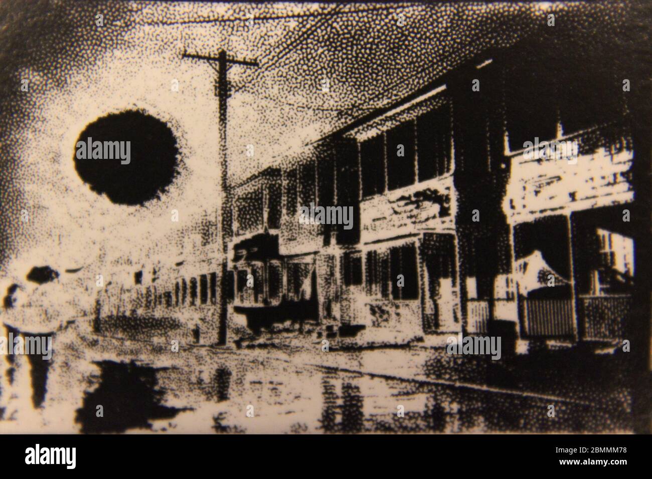 Fine anni '70 vintage in bianco e nero fotografia estrema di un sole che splende su una piccola città principale strada in America. Foto Stock