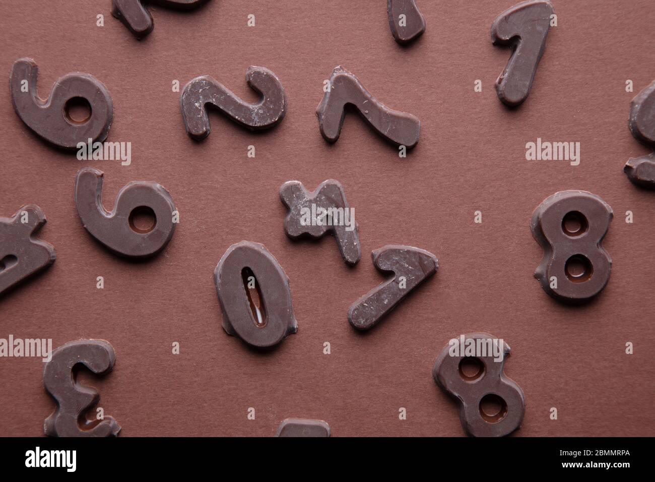 un'immagine artistica di numeri di cioccolato su sfondo marrone Foto Stock