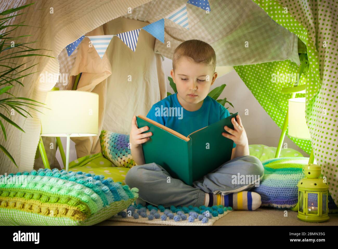 lettura e giochi per famiglie in tenda per bambini. Ragazzo con libro prima  di andare a letto Foto stock - Alamy