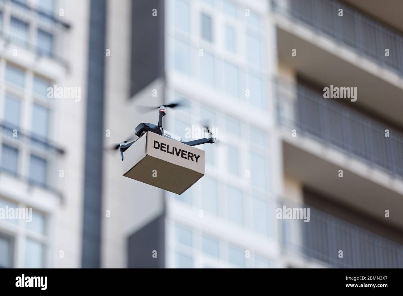 Spedizione di pacchi di cartone con drone in elicottero attraverso la città  Foto stock - Alamy